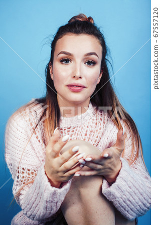 young pretty teenage modern hipster girl posing emotional happy on blue background, lifestyle people concept 67557120