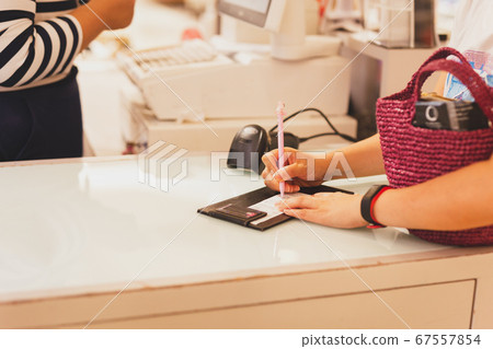 Consumer signature on a sale transaction receipt in shopping mall. 67557854