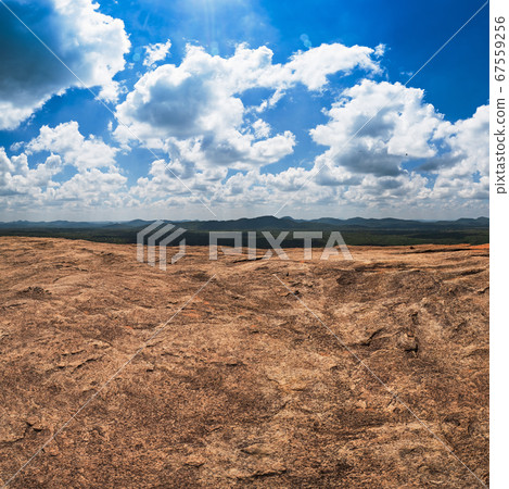 Massive rocks and view on blue cloudy sky  67559256