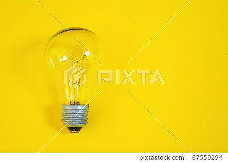 Incandescent light bulb on a yellow background. Incandescent light bulb on a yellow background. 67559294