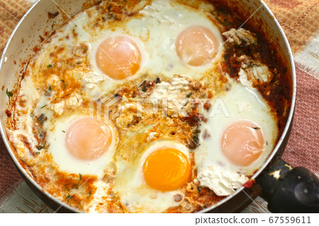 shakshuka - jewish national dish with fried eggs species, tomato, pepper garlic 67559611