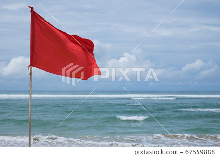 A red warning flag on the beach in the Nuca Dua 67559888