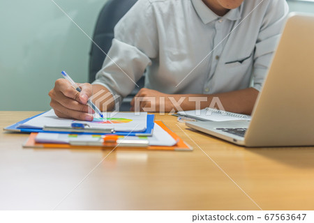 Man hand using pen to check financial number on document 67563647