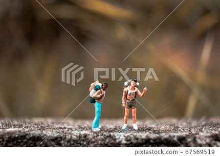 Miniature Backpacker standing on the concrete wall Miniature Backpacker standing on the concrete wall 67569519