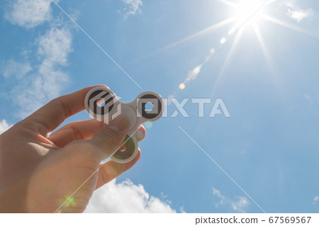 Hands holding fidget spinner toy 67569567
