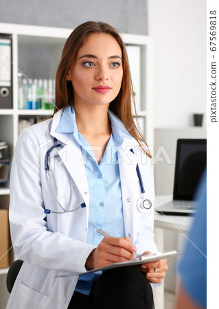 Female doctor hold hold in arm silver pen and pad 67569818