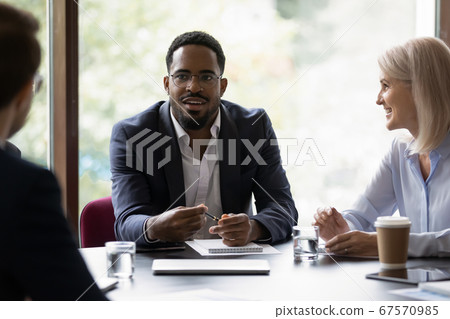 Businesspeople negotiating sit at desk focus on African businessman 67570985