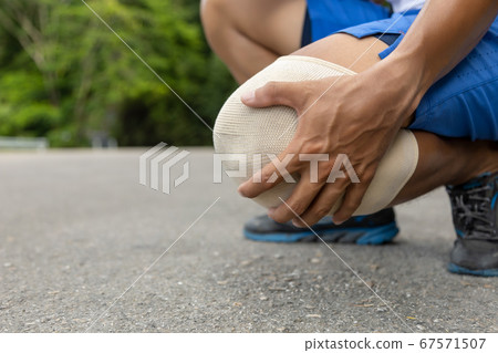 Man with blue runing shorts use hands hold on his 67571507