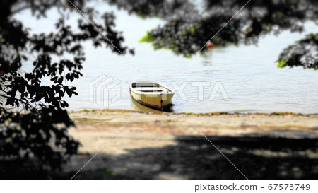 A small boat (diorama style) 1071 that reached the sandy beach looking out from the shade of the tree A small boat (diorama style) 1071 that reached the sandy beach looking out from the shade of the tree 67573749