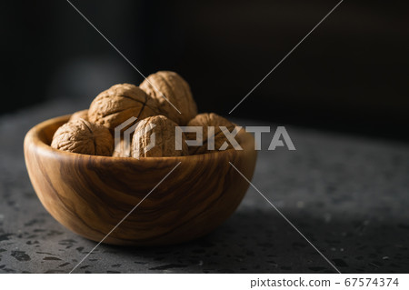 inshell walnuts in olive wood bowl on terrazzo countertop inshell walnuts in olive wood bowl on terrazzo countertop 67574374