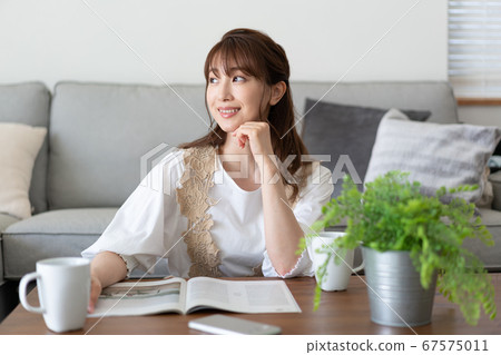 讀一本雜誌在一杯茶的少婦在客廳 讀一本雜誌在一杯茶的少婦在客廳 67575011