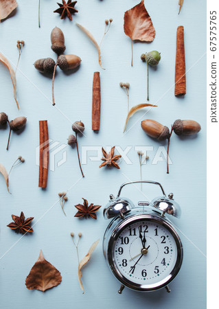 Autumn time composition with clock and dry foliage 67575765