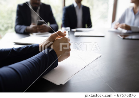 Businessman participates in meeting, put his hands on table closeup 67576870