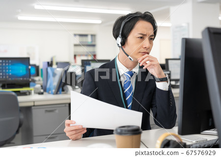 網絡會議一個年輕的商人，盯著屏幕與收入 67576929