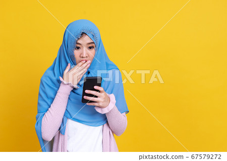 Smiling Asian muslim woman with using mobile or Smiling Asian muslim woman with using mobile or 67579272