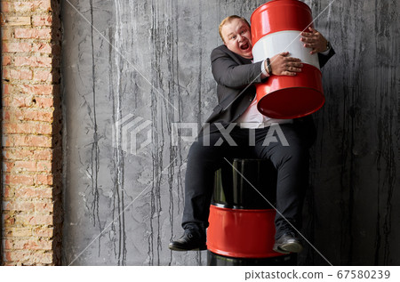 cheerful fat businessman is not ready to give someone profit, oil production concept cheerful fat businessman is not ready to give someone profit, oil production concept 67580239