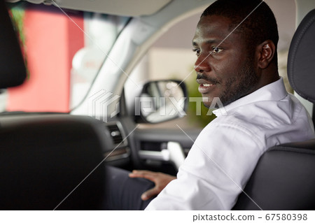 african couple sit inside of car and discuss it before purchase 67580398
