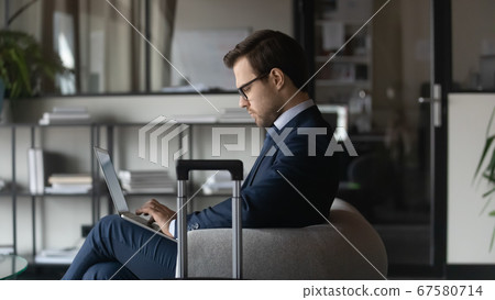 Serious businessman in office prepared for business trip 67580714