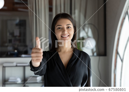 Portrait of smiling indian female employee show thumb up Portrait of smiling indian female employee show thumb up 67580801