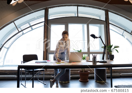 Concentrated female employee prepare report in office 67580815