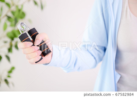 A woman who uses her hand grip to improve her grip 67582984