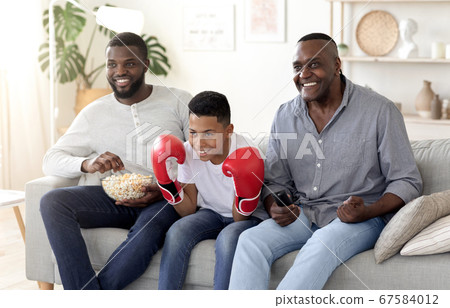 Black Dad, Son And Grandfather Watching Boxing Match On Tv And Cheering Black Dad, Son And Grandfather Watching Boxing Match On Tv And Cheering 67584012