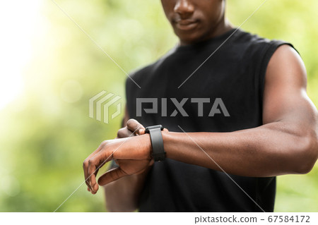Cropped of black sportsman using his smartwatch 67584172