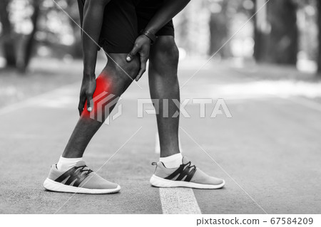 Closeup of african sportsman injured during running leg 67584209