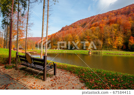 small lake in autumn park. forest on the hills in 67584411
