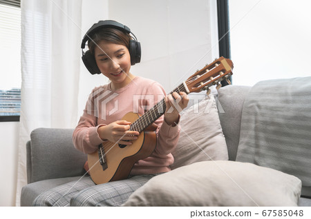 Asian woman blogger recording and live steam playing guitar on social media 67585048