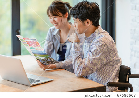 Men and women making plans while looking at travel brochures 67586608