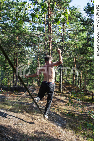 young man doing slackline rodeo in forrest outside sports activities, lifestyle people concept young man doing slackline rodeo in forrest outside sports activities, lifestyle people concept 67586992