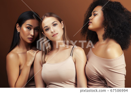 young pretty asian, caucasian, afro woman posing cheerful together on brown background, lifestyle diverse nationality people concept young pretty asian, caucasian, afro woman posing cheerful together on brown background, lifestyle diverse nationality people concept 67586994