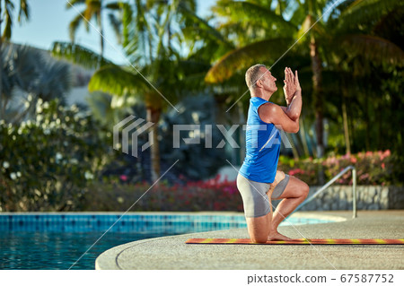 A man practice yoga near to swimming pool A man practice yoga near to swimming pool 67587752
