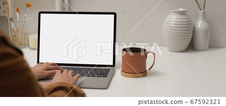 Female typing on mock up laptop on white table Female typing on mock up laptop on white table 67592321