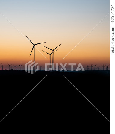 Black Silhouette of windturbines energy generator on amazing sunset at a wind farm in germany Black Silhouette of windturbines energy generator on amazing sunset at a wind farm in germany 67594724