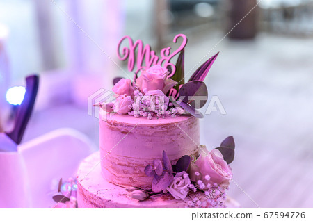Beautiful wedding cake with cream With text MR MRS on top pink flowers roses Beautiful wedding cake with cream With text MR MRS on top pink flowers roses 67594726