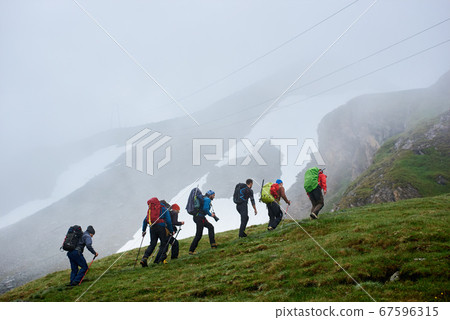 Group of travelers climbing the mountain. 67596315
