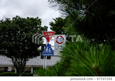 Combination of traffic signs in the city Pause Pedestrian crossing End of maximum speed Bokeh in front of roadside tree Combination of traffic signs in the city Pause Pedestrian crossing End of maximum speed Bokeh in front of roadside tree 67597268