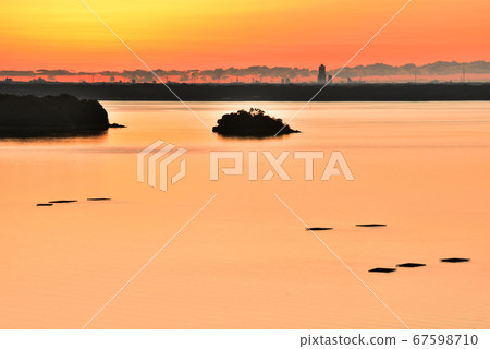 A small island floating on the orange surface of the lake 67598710