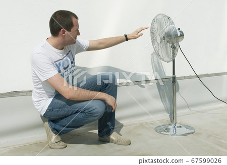 guy at the wall on the roof. near fan 67599026