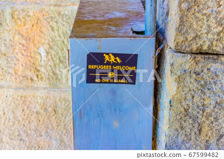 The road sign symbol with text Refugees welcome 67599482