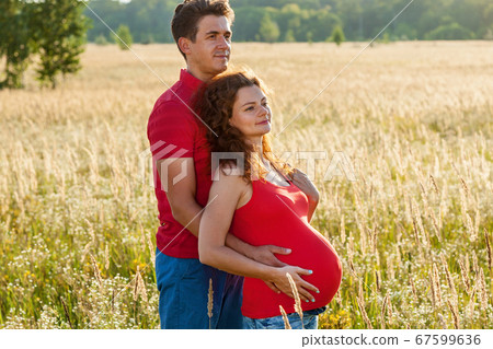 A happy couple is posing in the wheat field A happy couple is posing in the wheat field 67599636
