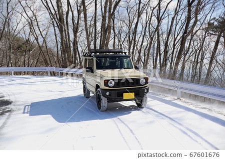 四輪驅動的微型汽車在雪道上行駛。 四輪驅動的微型汽車在雪道上行駛。 67601676