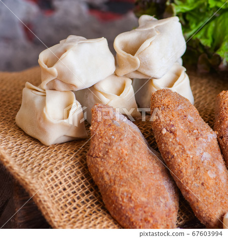 Raw homemade cutlets and manti. Close up. Raw homemade cutlets and manti. Close up. 67603994