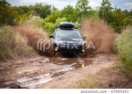 Black Subaru Forester moving at dirty forest road Black Subaru Forester moving at dirty forest road 67604263
