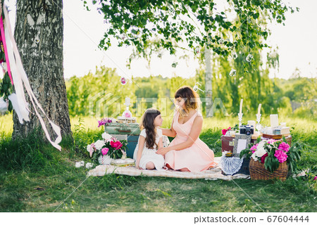 happy beautiful mother and daughter resting on a blanket in nature on a summer happy beautiful mother and daughter resting on a blanket in nature on a summer 67604444