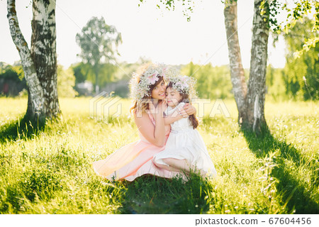 happy beautiful mother with a daughter of Caucasian appearance hugging in the meadow 67604456