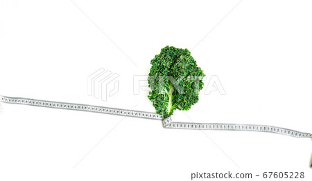 kale wrapped in measuring tape, concept diet, slimming, healthy eating top view, on white background kale wrapped in measuring tape, concept diet, slimming, healthy eating top view, on white background 67605228