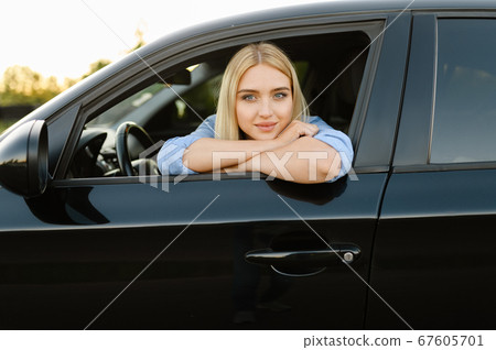 Female student poses in car, driving school 67605701